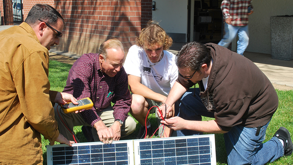 students and instructor around solar panel